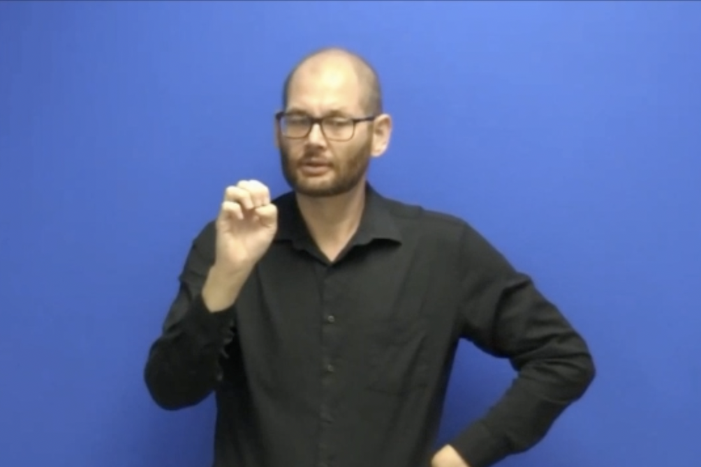 Screenshot of a man signing from the video of an example of interpretations of life science terms.
